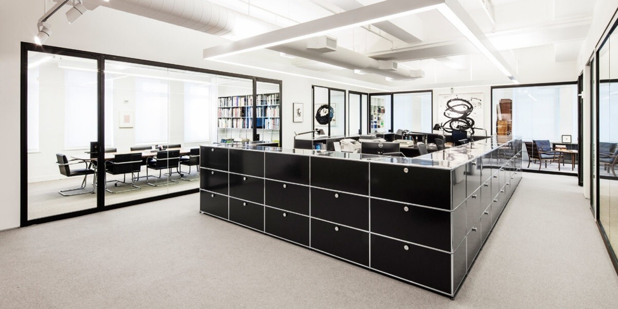 a common area surrounded by private offices with low-iron glass walls